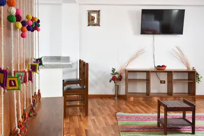 a living room with a television and a table at Apart Hotel El Puma in Cusco