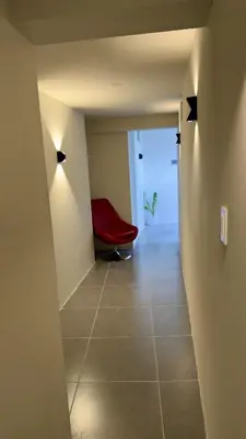 a hallway with a red chair in a room at Habitación con Balcón Castellares La Puebla in Ayacucho