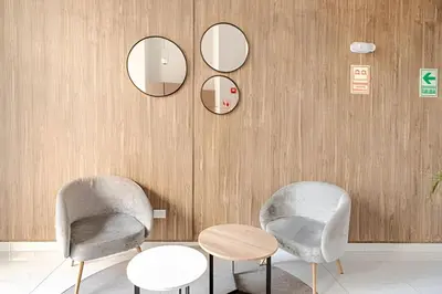 two chairs and a table in a room with mirrors at Edificio Vital in Lima