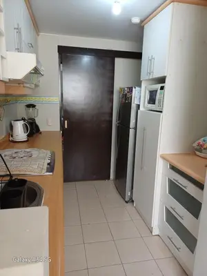 a kitchen with a black door and a refrigerator at Cómodo departamento familiar in Lima