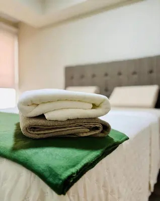 three towels are stacked on top of a bed at Modern and centrally located with a rooftop in Lima