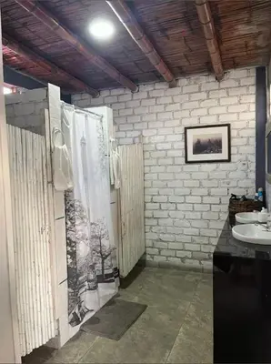 a bathroom with a sink and a white brick wall at Casa campo vista linda in Mala