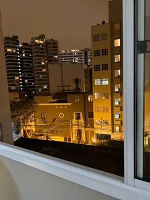 a view of a city at night from a window at The Palms at Miraflores in Lima