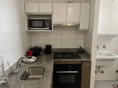 a small kitchen with a sink and a microwave at Emilia House in Lima