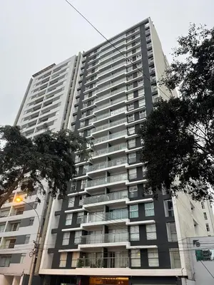 a tall apartment building with trees in front of it at Emilia House in Lima