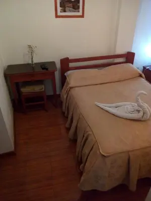 a bedroom with two beds with a swan towel on the bed at Hostal Cusco Inn in Cusco