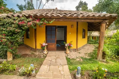 a small yellow house with a wooden door at Andean Wings Valley in Urubamba