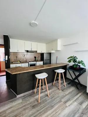 a kitchen with a counter and two stools in it at Monterrico Polo Aparts #3 - Dpto con AC a una cuadra Embajada de USA in Lima