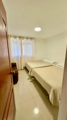 a room with two beds and a door with a door at Departamento completo en el primer piso in Ayacucho