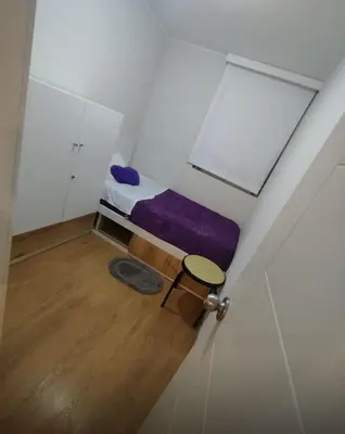 a small room with a purple bed and a table at Departamento Costanera frente al mar in Lima