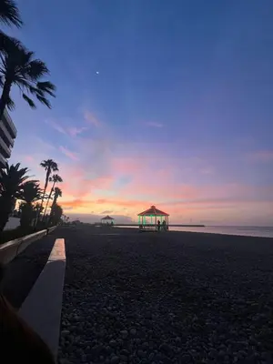 a view of a beach with a gazebo at sunset at Cuchos in Lima
