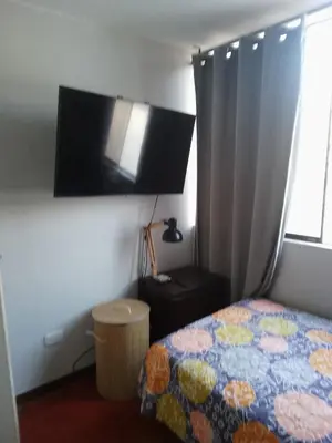 a bedroom with a bed and a flat screen tv at Cuchos in Lima