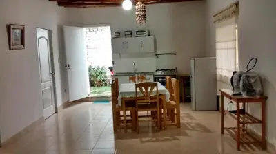 a kitchen with a table and chairs and a refrigerator at Casa Langla Lunahuana in Lunahuaná