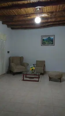 a living room with two chairs and a table at Casa Langla Lunahuana in Lunahuaná