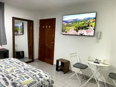 a bedroom with a bed and a tv on the wall at Wake Up Near The Sea in Lima