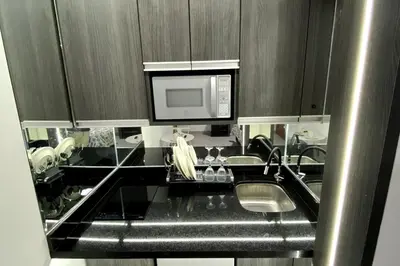 a kitchen with a sink and a microwave at Wake Up Near The Sea in Lima