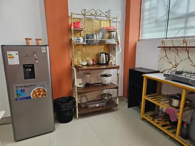 a kitchen with a refrigerator and a shelf with dishes at Familiar 1er piso in La Merced
