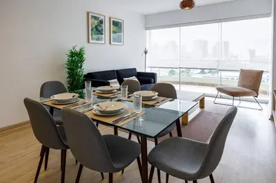 a living room with a dining room table and chairs at BSR Flat los Andes near Airport in Lima