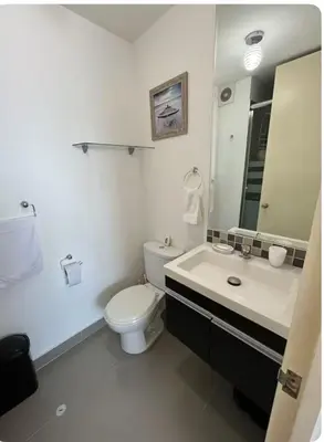 a bathroom with a toilet and a sink and a mirror at Departamento con balcon y vista al mar in Lima