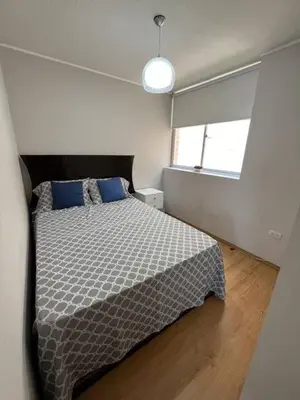 a bedroom with a bed with a black and white comforter at Departamento con balcon y vista al mar in Lima
