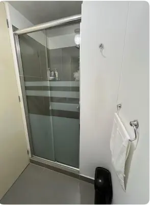a shower with a glass door in a bathroom at Departamento con balcon y vista al mar in Lima