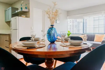 a dining room table with a blue vase on it at Appealing 1BR Beautiful View in Miraflores in Lima