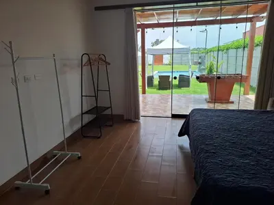 a bedroom with a room with a bed and a glass door at Condominio ecológico las gardenias de Asia