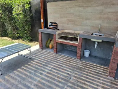 a barbecue grill and a sink on a patio at Condominio ecológico las gardenias de Asia
