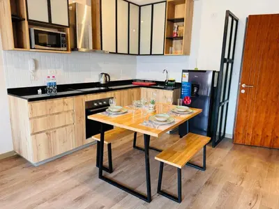 a kitchen with a wooden table and a black refrigerator at Monterrico Polo Aparts 19 - Dpto de Estreno con Balcon frente Embajada USA in Lima
