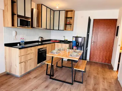 a kitchen with a table with chairs and a counter top at Monterrico Polo Aparts 19 - Dpto de Estreno con Balcon frente Embajada USA in Lima