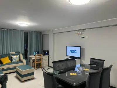 a living room with a tv and a table and chairs at Alojamiento ideal Equipado in Huancayo
