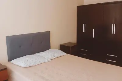 a bedroom with a bed and a black cabinet at Apartamento cómodo con piscina en el Centro Histórico, Lima in Lima