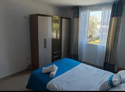 a bedroom with a blue bed and a window at CASA HOSPEDAJE Conquistadores Inn