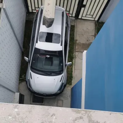 an overhead view of a white car parked in a garage at CASA HOSPEDAJE Conquistadores Inn