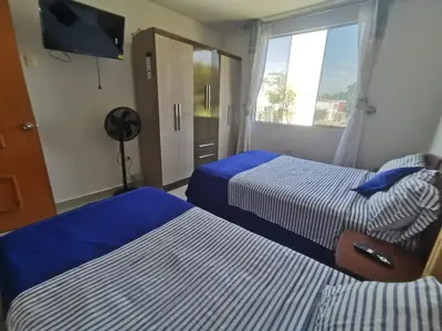 a hotel room with two beds and a flat screen tv at CASA HOSPEDAJE Conquistadores Inn