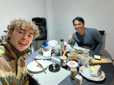 two men sitting at a table eating food at El Rosedal in Lima