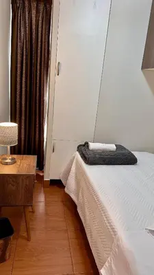 a bedroom with a bed and a table and a window at Hermoso Departamento Frente al Escuela de Oficiales de La policia in Lima