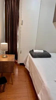 a bedroom with a bed and a table and a lamp at Hermoso Departamento Frente al Escuela de Oficiales de La policia in Lima