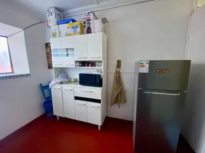 a small kitchen with a refrigerator and white cabinets at Guadita House in Cusco