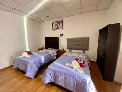 a room with two beds with hats on them at Guadita House in Cusco