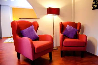 two orange chairs with purple pillows next to a lamp at Historical Center Apartments in Cusco