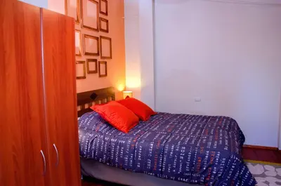 a bedroom with a bed with red pillows on it at Historical Center Apartments in Cusco