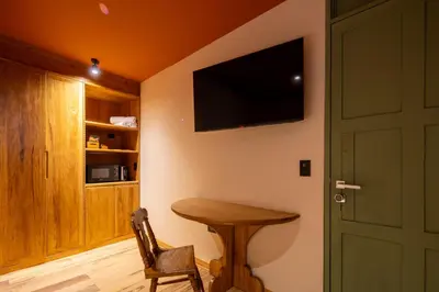 a room with a wooden table and a television on a wall at Hotel 1821 in Cusco