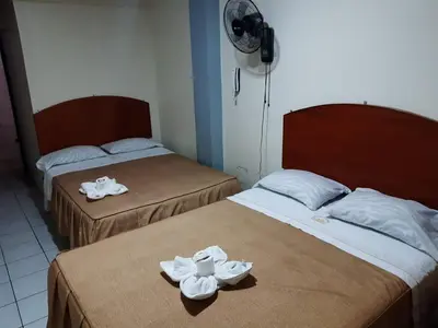 two beds with towels on them in a room at Hs Corona in Lima