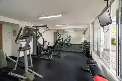 a gym with several tread machines and a flat screen tv at Departamento en Barranco in Lima