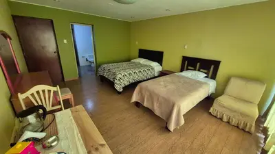 a room with two beds and a chair in it at Dormitorio con baño privado a 25 minutos del Apto in Lima