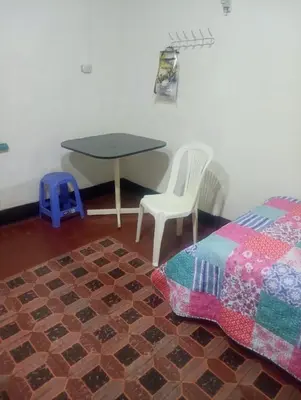 a bedroom with a table and a table and a chair at Habitación Plaza Chosica in Chosica