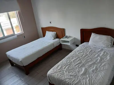 a bedroom with two beds and a window at Miraflores Pacific Hotel in Lima