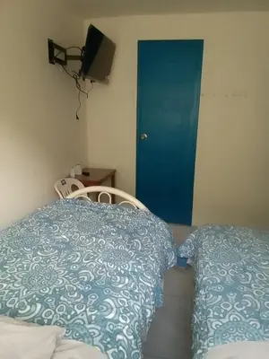 a bedroom with a bed and a blue door at Hospedaje TUTUMEME in Churín