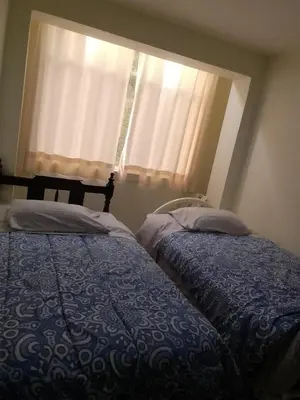 a bedroom with two beds in front of a window at Hospedaje TUTUMEME in Churín